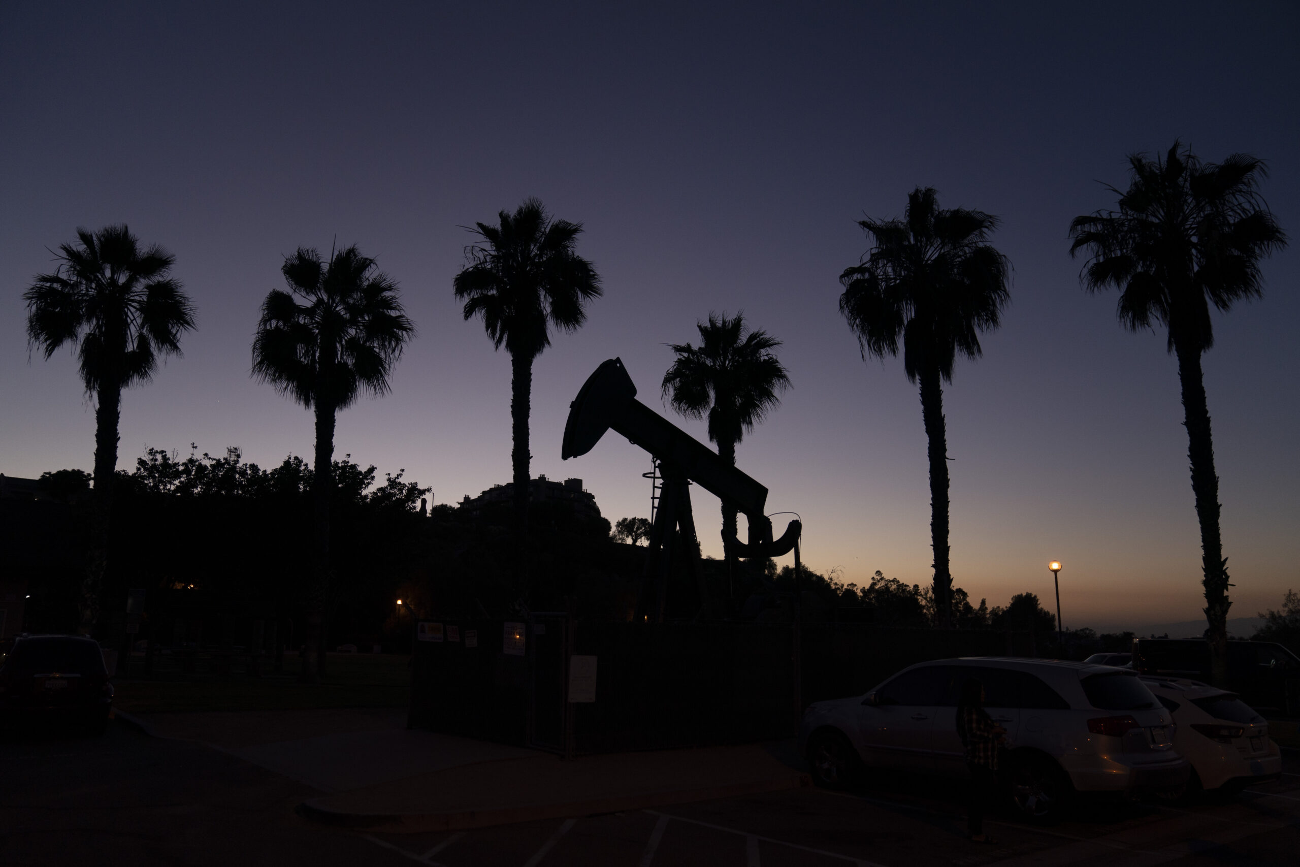 FILE - A pump jack sits idle in front of palm trees on June 9, 2021, in Signal Hill, Calif. Califor...