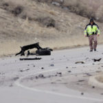 A Utah Highway Patrol trooper walks toward the debris field as UHP and Salt Lake City Police investigate after a collision between two cars at 700 North just off of I-215 in Salt Lake City on Friday, Mar. 3, 2023. (Deseret News	/Scott G Winterton),
