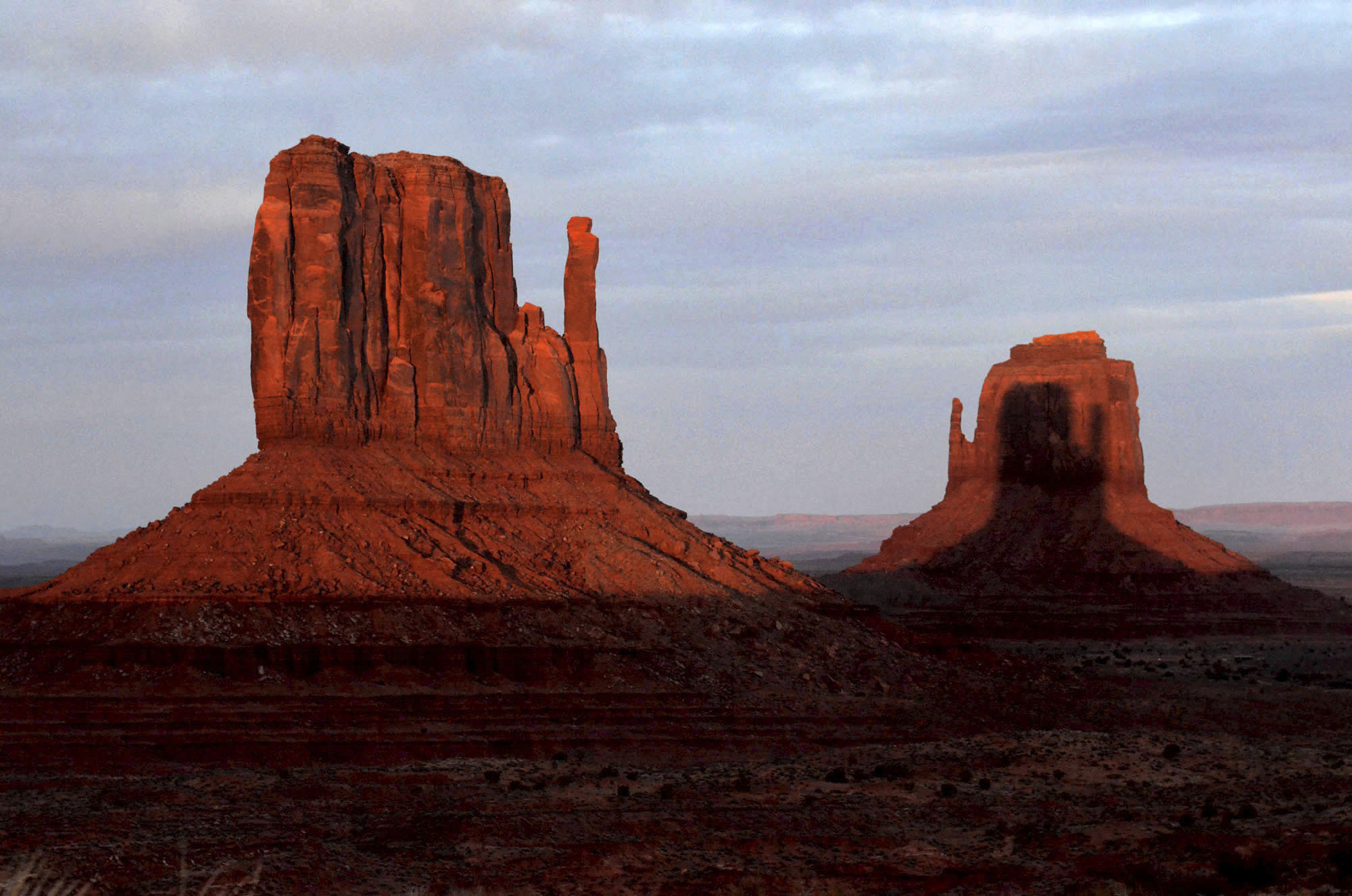 A sunset spectacle featuring two mitten-shaped rock formations crosses Monument Valley Tribal Park ...