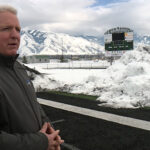 Dave Swenson in front of the snow piles on the football field. (Mike Anderson/KSL TV)