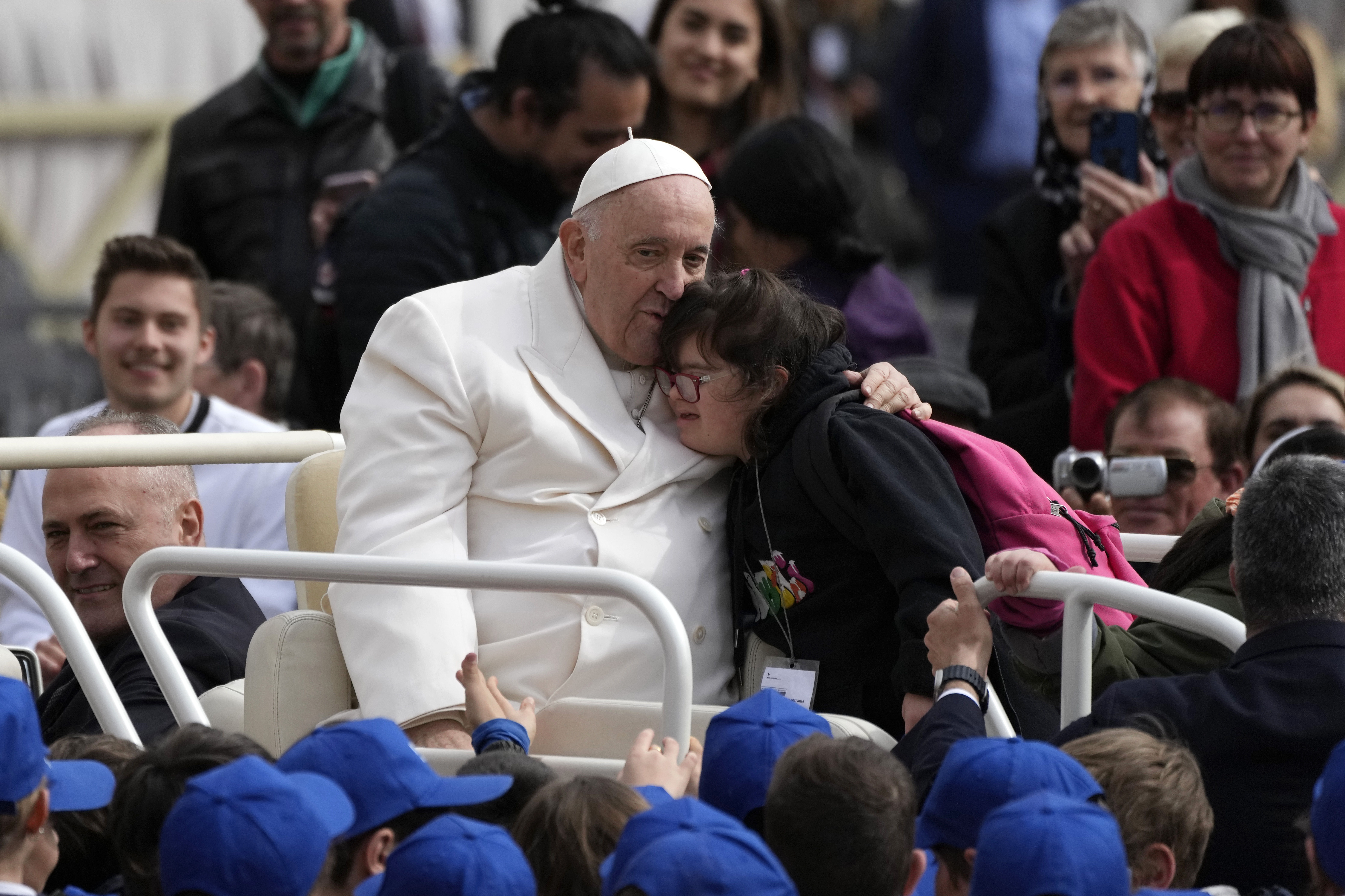 Pope Francis hugs a child at the end of his weekly general audience in St. Peter's Square, at the V...