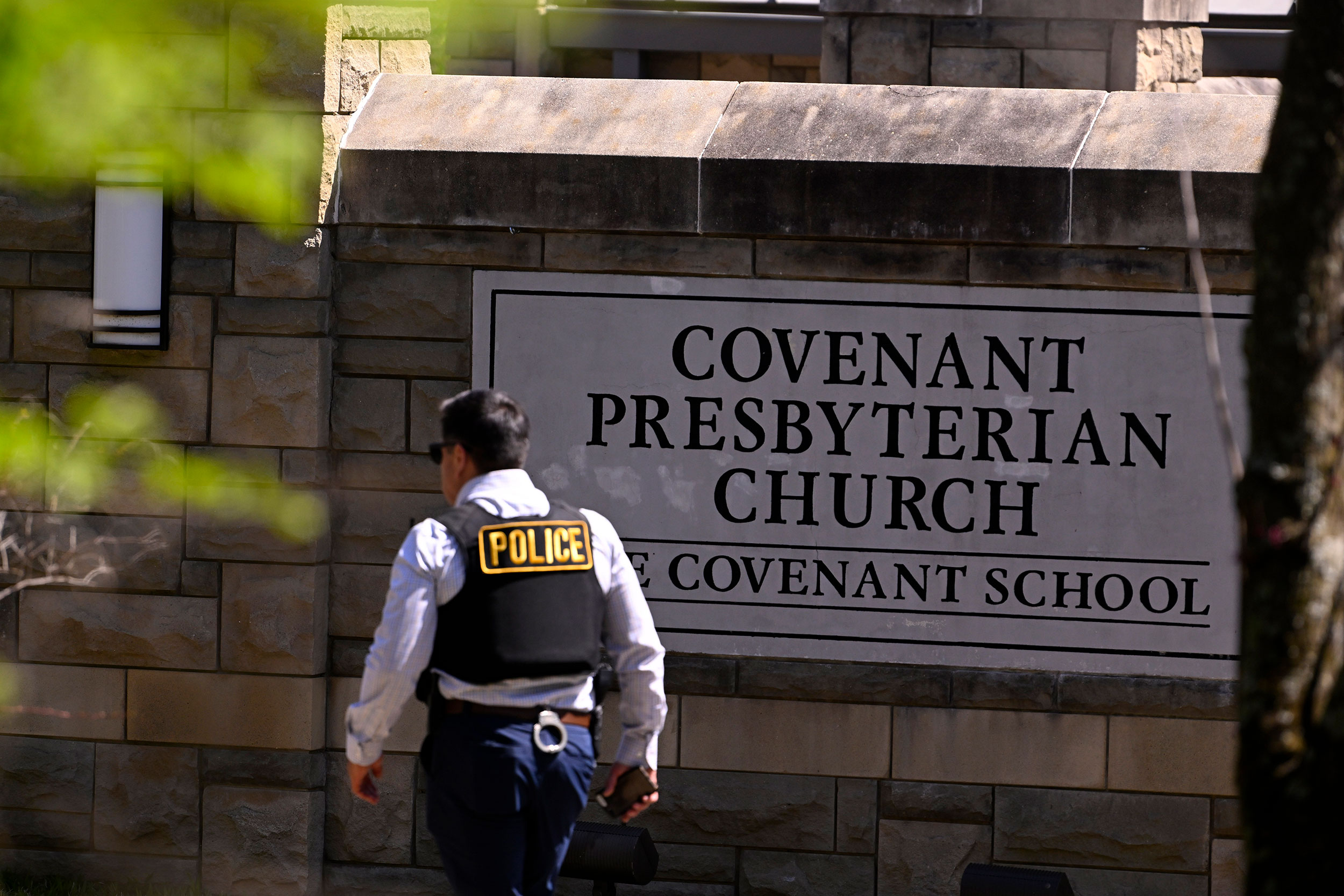 A police officer walks by an entrance to The Covenant School after a shooting in Nashville, Tenn. o...