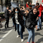 Protesters shout towards gas-throwing riot police during a massive demonstration in Athens on March 5, 2023, following the deadly train accident late on February 28. (Louisa Gouliamaki/AFP/Getty Images)