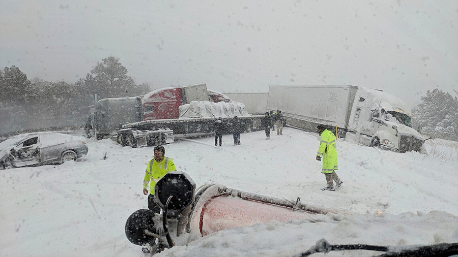 Semi trucks and cars are off the road in a car crash in deep snow....