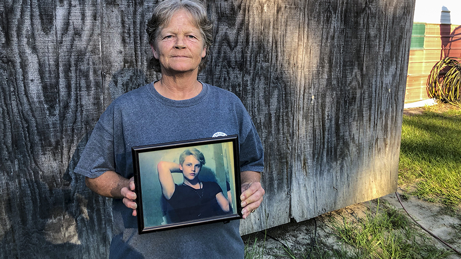 FILE - Sandy Smith holds a photo of her late son, 19-year-old Stephen Smith, on June 24, 2021, in H...