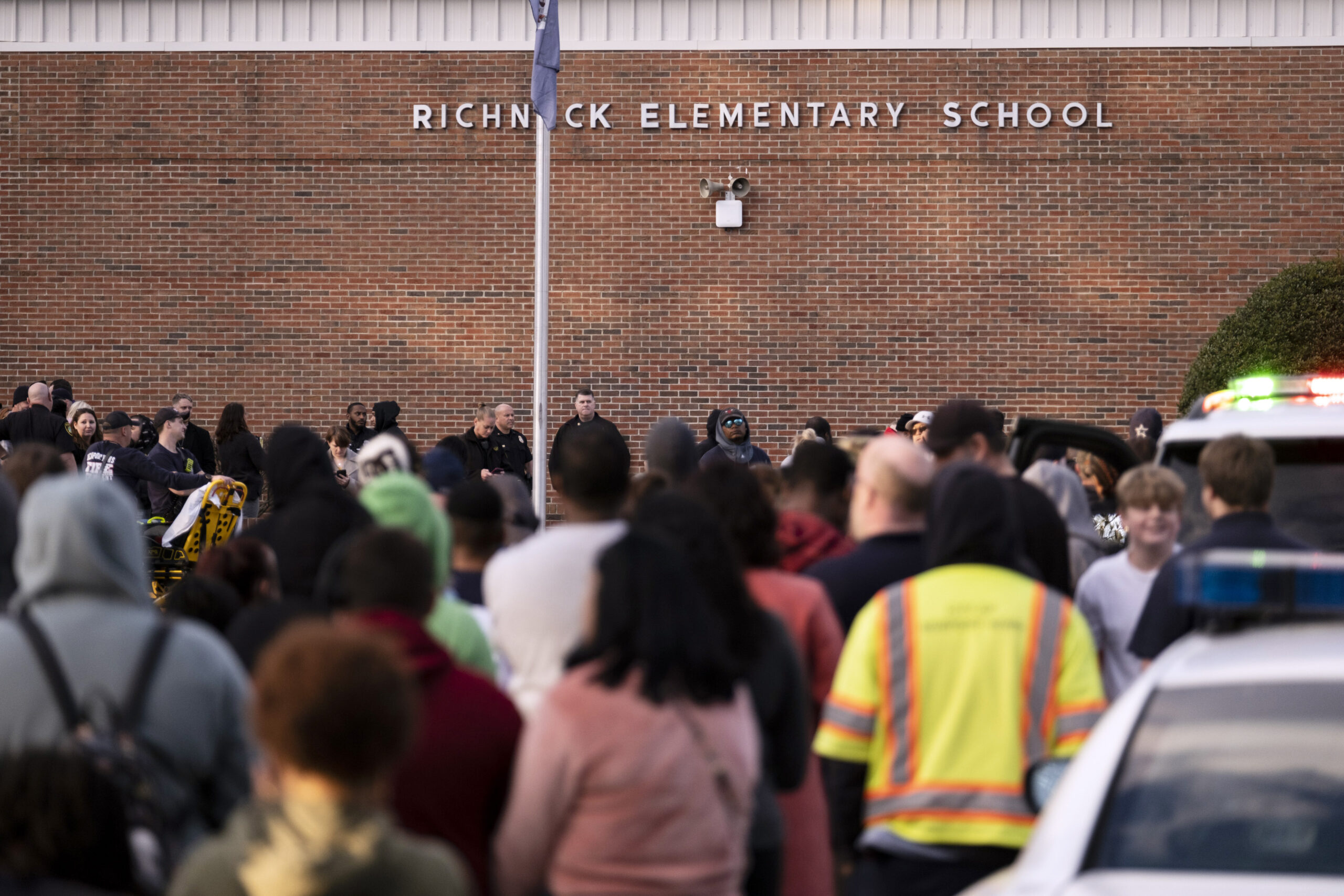 FILE - Students and police gather outside of Richneck Elementary School after a shooting, Jan. 6, 2...