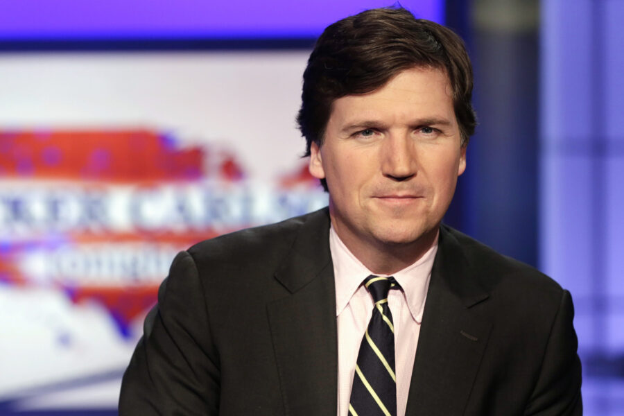 FILE - Tucker Carlson, host of "Tucker Carlson Tonight," poses for photos in a Fox News Channel stu...