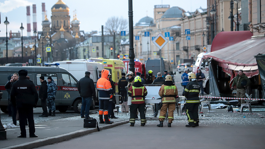 Emergency service workers stand at the site of the blast at the St. Petersburg cafe on Sunday. Russ...