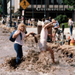 Pedestrians cross the human-made river of water on State Street during the floods of 1983 in Salt Lake City. (Ravell Call/Deseret News)