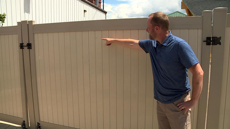 Lane Mugleston, owner of Leap Ahead Daycare, showing the bullet hole left in the fence. (KSL TV)...