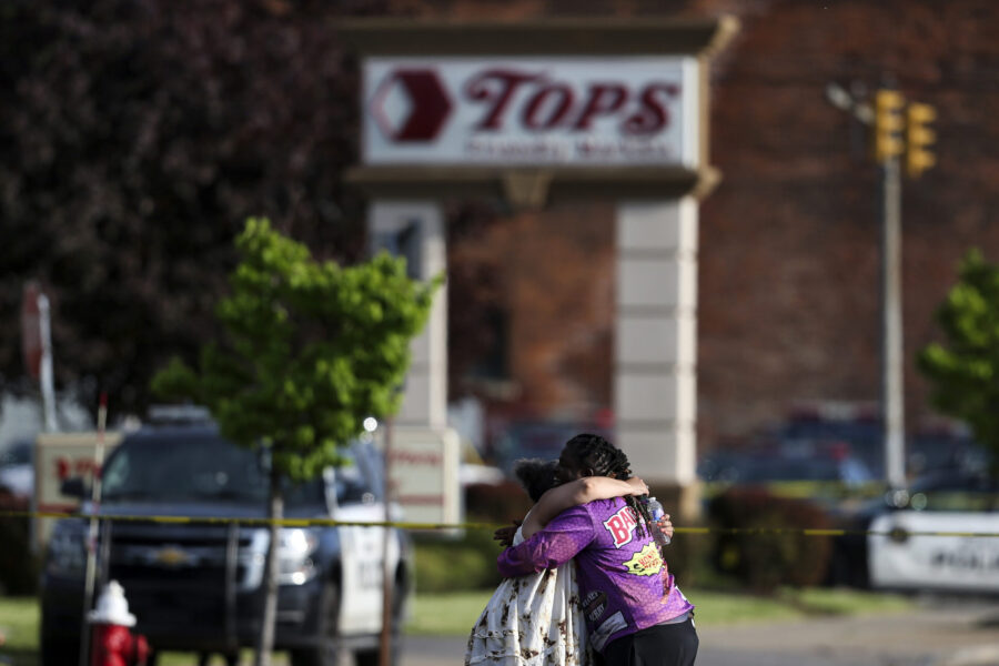 FILE - People hug outside the scene after a shooting at Tops supermarket, May 14, 2022, in Buffalo,...