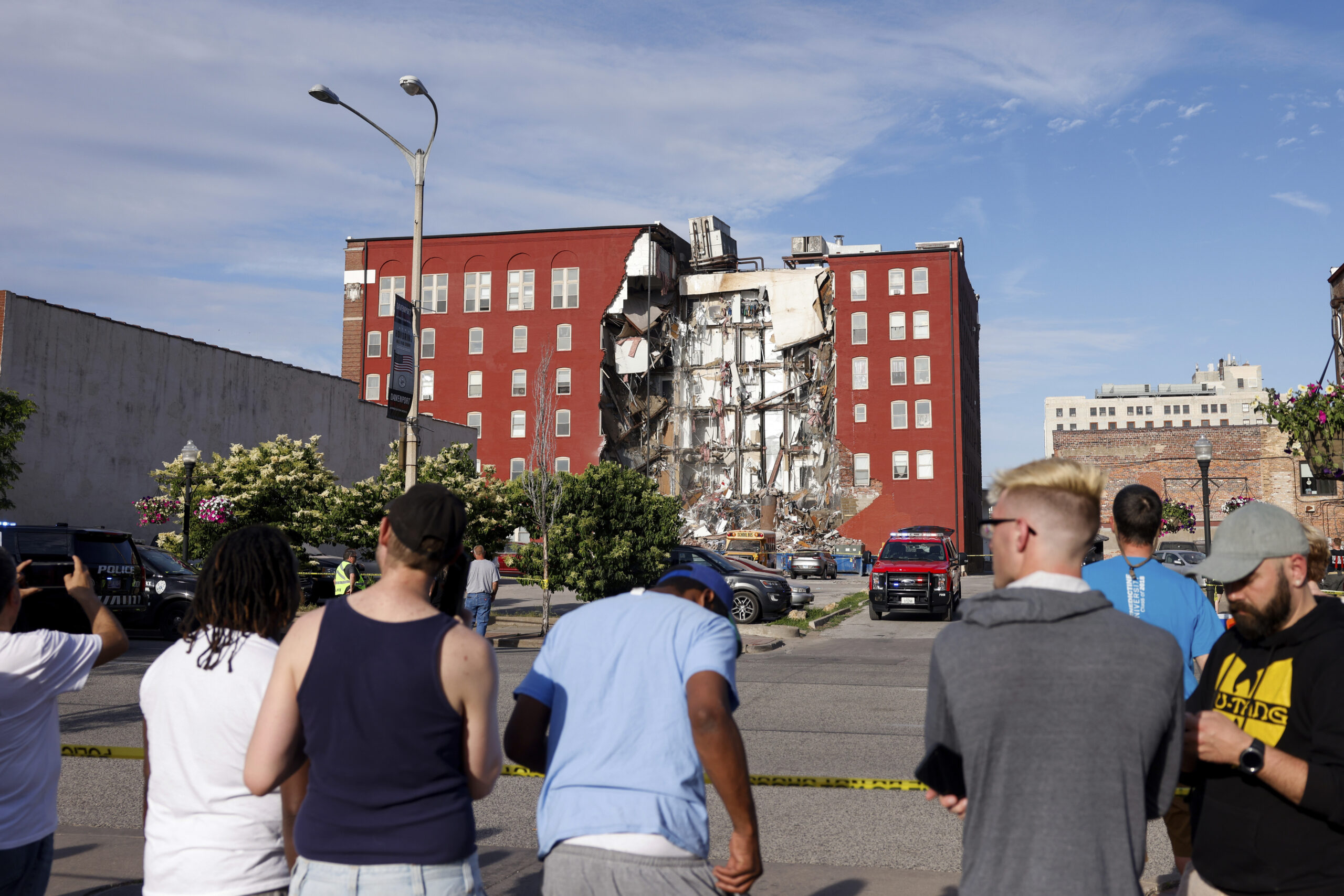 Onlookers watch as emergency crews work the scene of a partial building collapse on the 300 block o...