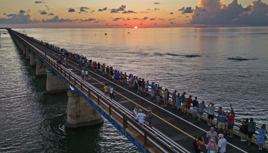 In this aerial photo provided by the Florida Keys News Bureau, attendees watch and toast the sunset...