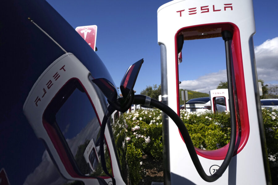 FILE - A Tesla auto charges on May 10, 2023, in Westlake, Calif. All of Ford Motor Co.'s current an...