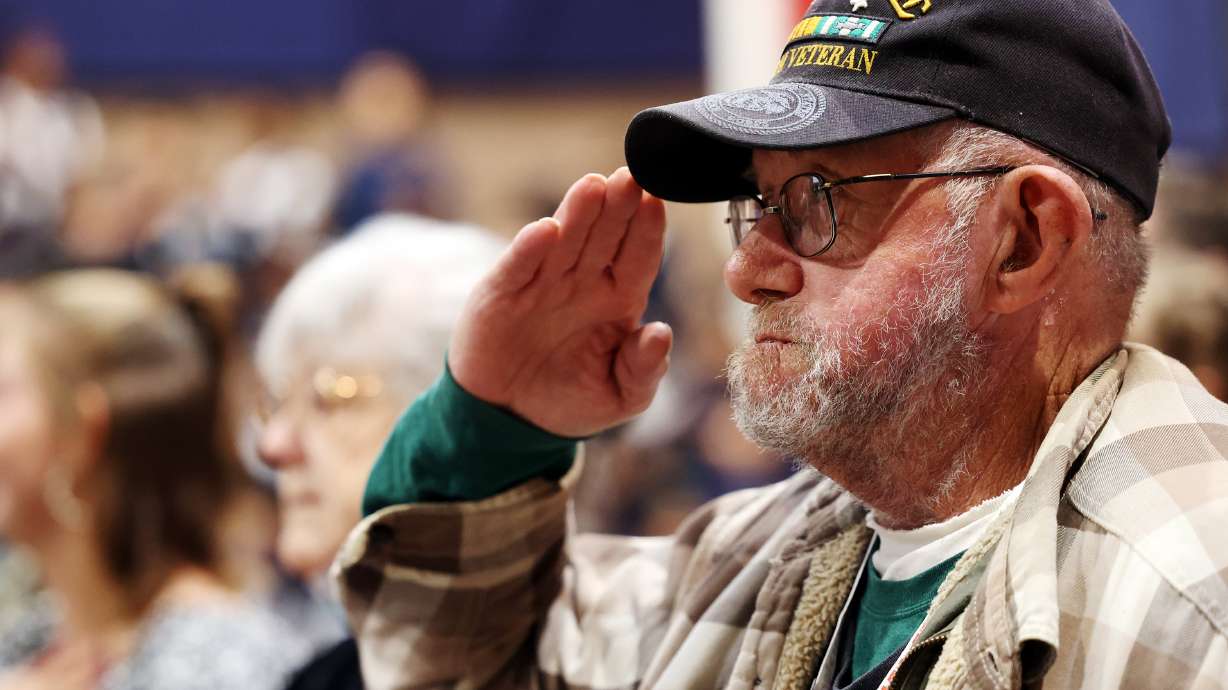 Veteran Michael West salutes during the posting of the colors at American Preparatory Academy in We...