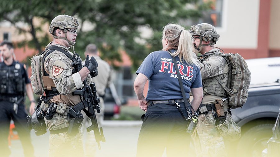 A member of the Salt Lake City Police Department’s SWAT Team speaks with a firefighter and a SLCP...