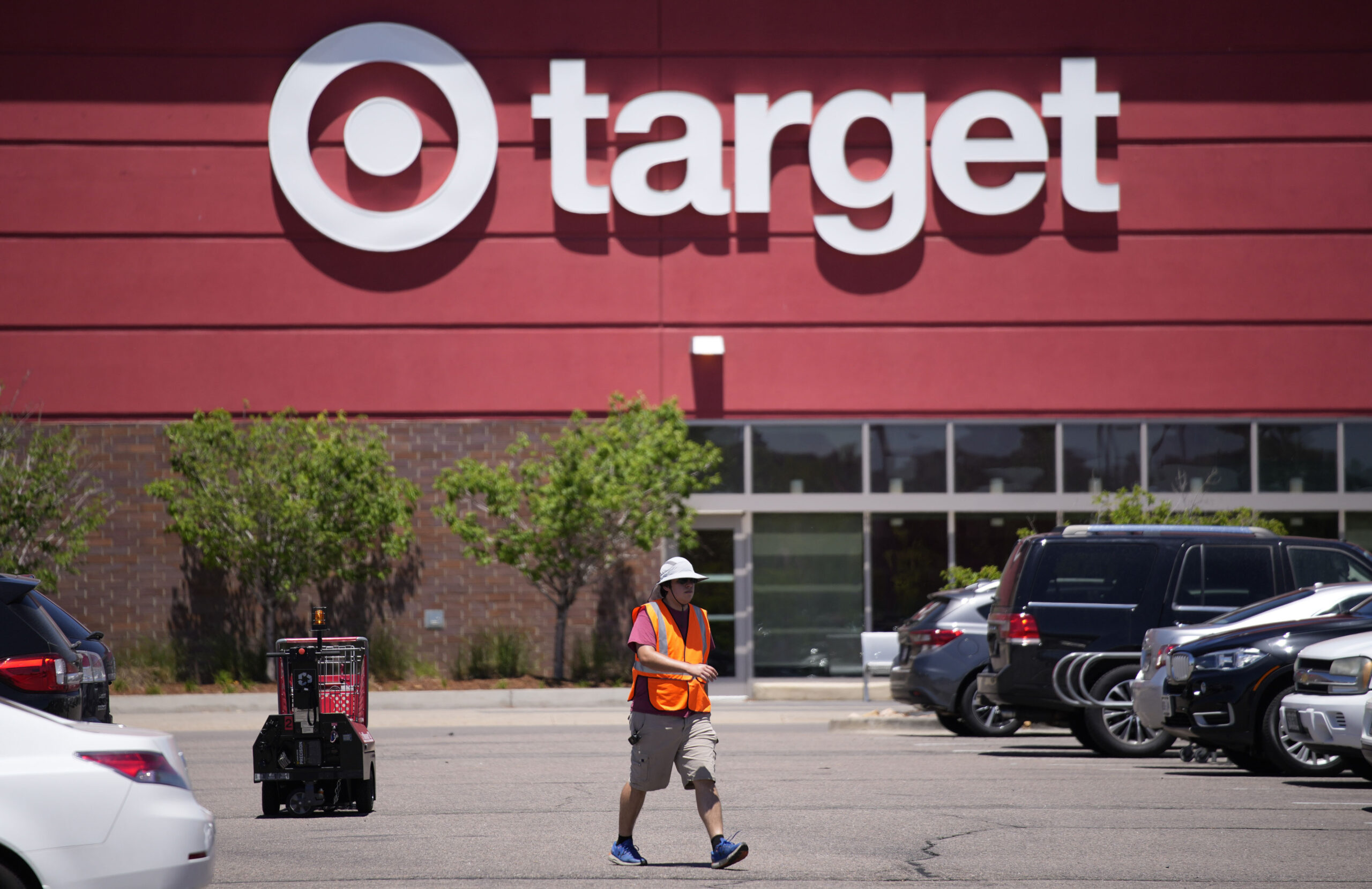 FILE - A worker collects shopping carts in the parking lot of a Target store on June 9, 2021, in Hi...