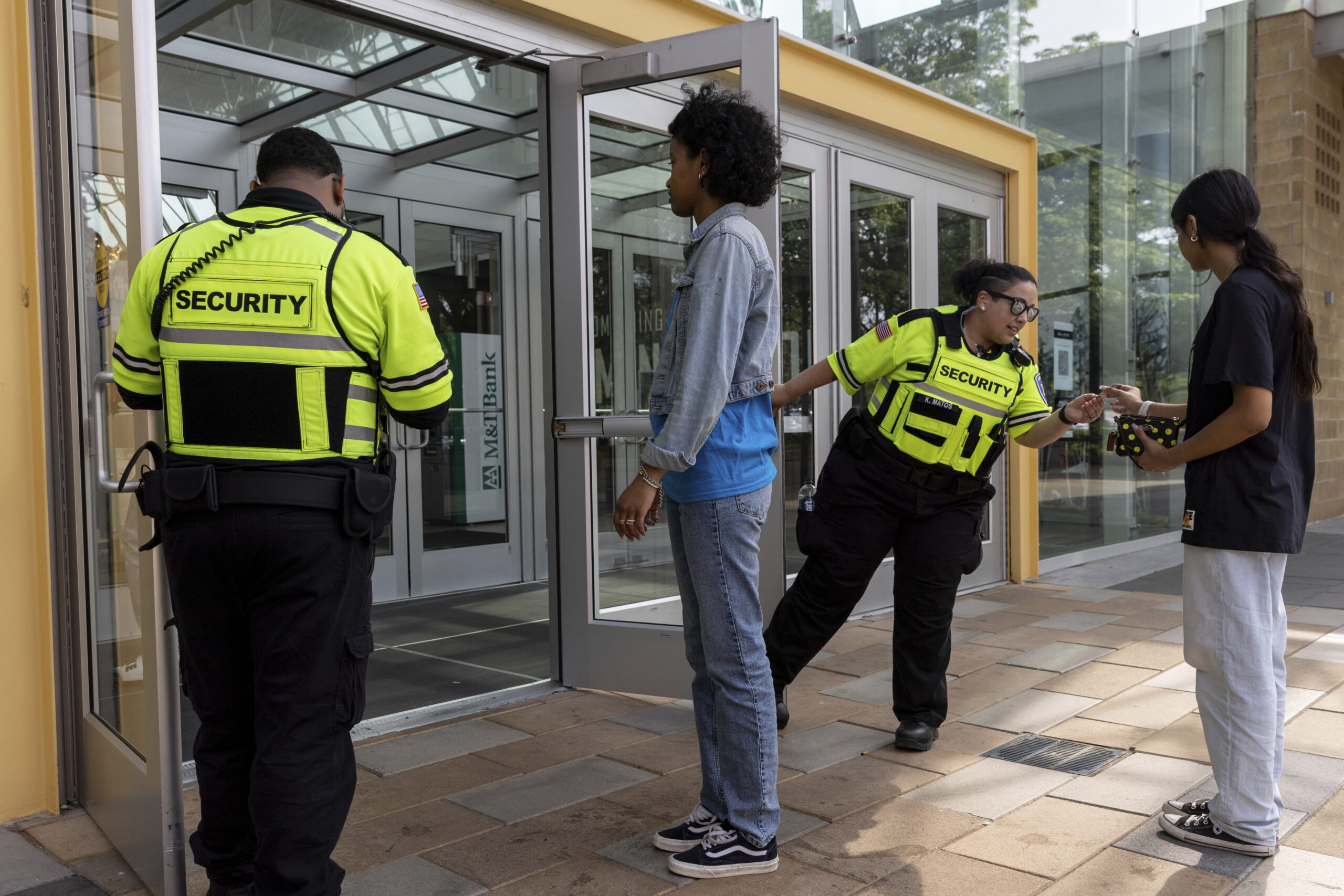 Security guards check identification for proof of age outside the Mall in Columbia, Friday, May 12,...