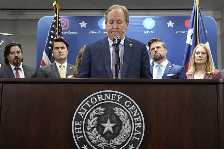 Texas state Attorney General Ken Paxton, center, flanked by his staff, makes a statement at his off...