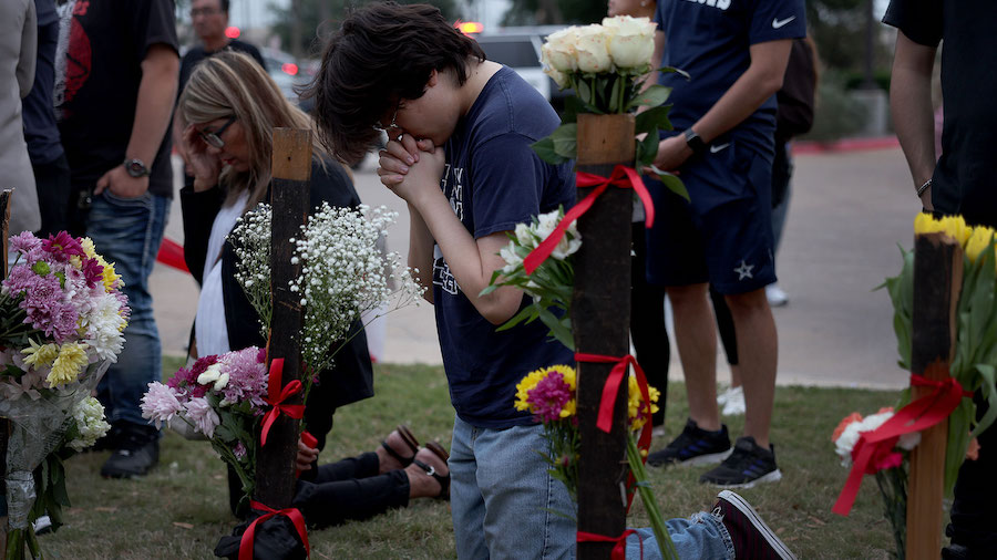 Carson Smith prays Sunday at a memorial next to Allen Premium Outlets. (Joe Raedle/Getty Images via...