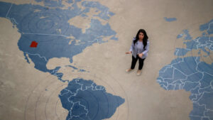 Reporter standing on a giant map