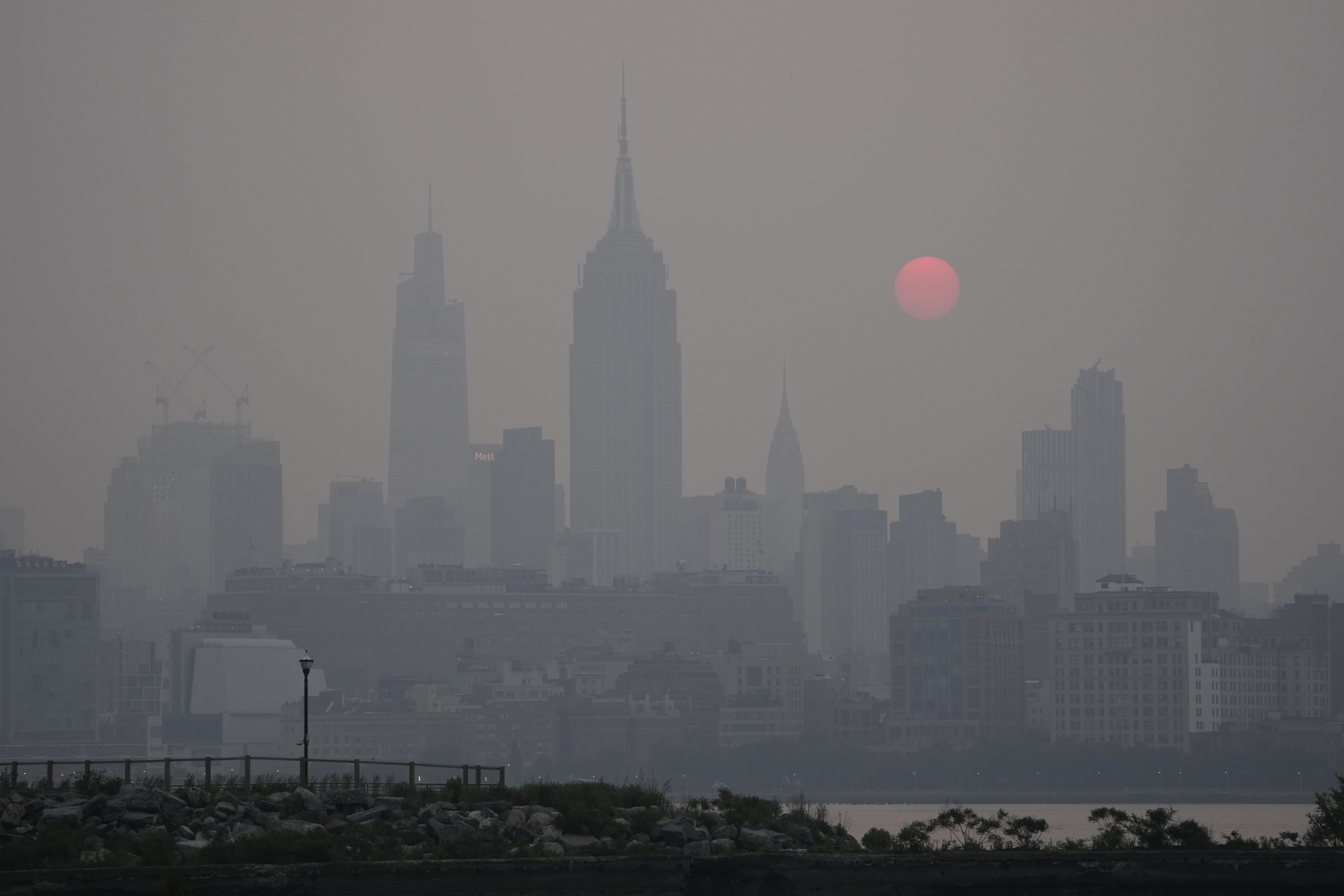 The sun rises over a hazy New York City skyline as seen from Jersey City, N.J., Wednesday, June 7, ...