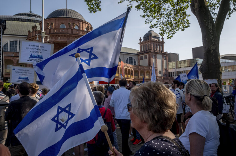 Women hold Israeli flags as they take part in a demonstration against a concert later the day of fo...