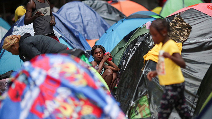 Migrants from Haiti look on outside their tent in the Giordano Bruno park, while they wait for the ...