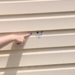 Erica Farr, showing the bullet hole she found next to her building. (KSL TV)