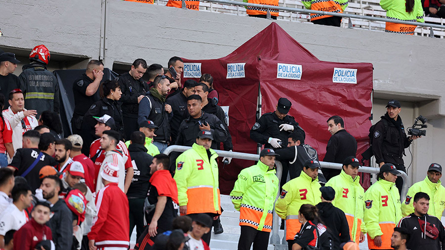 Police and firefighters work at the site where a spectator fell from the top of a grandstand during...