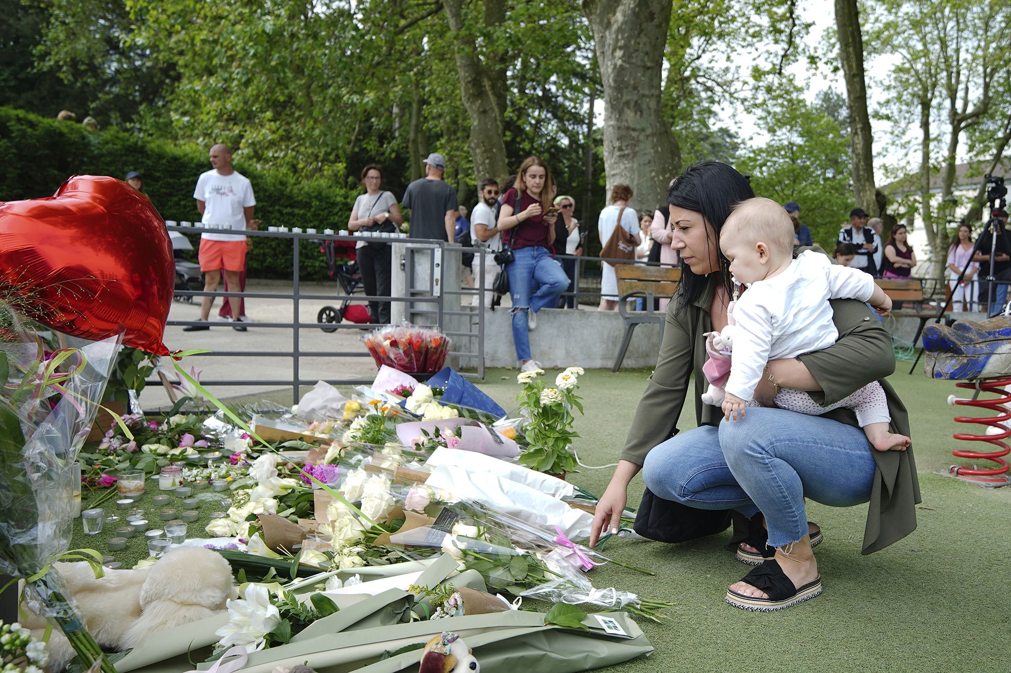 People lay flowers near the scene at a lakeside park in Annecy, France, on June 9, after a knife at...