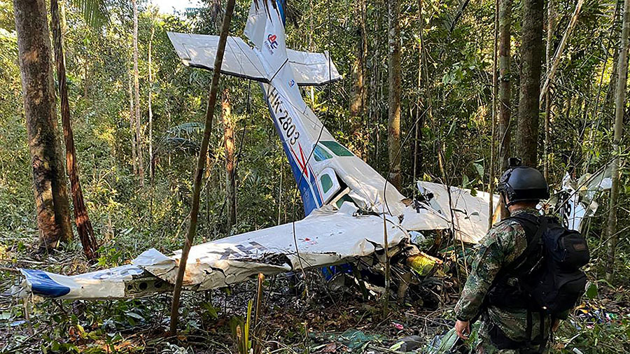 Soldier stands in front of plane crash in jungle...
