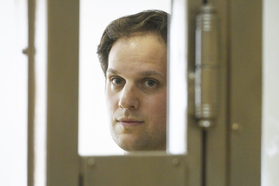 Wall Street Journal reporter Evan Gershkovich stands in a glass cage in a courtroom at the Moscow C...