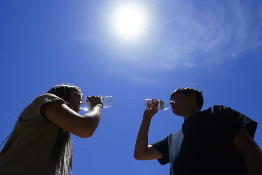 Tony Berastegui Jr., 15, right, and his sister Giselle Berastegui, 12, drink water as temperatures ...