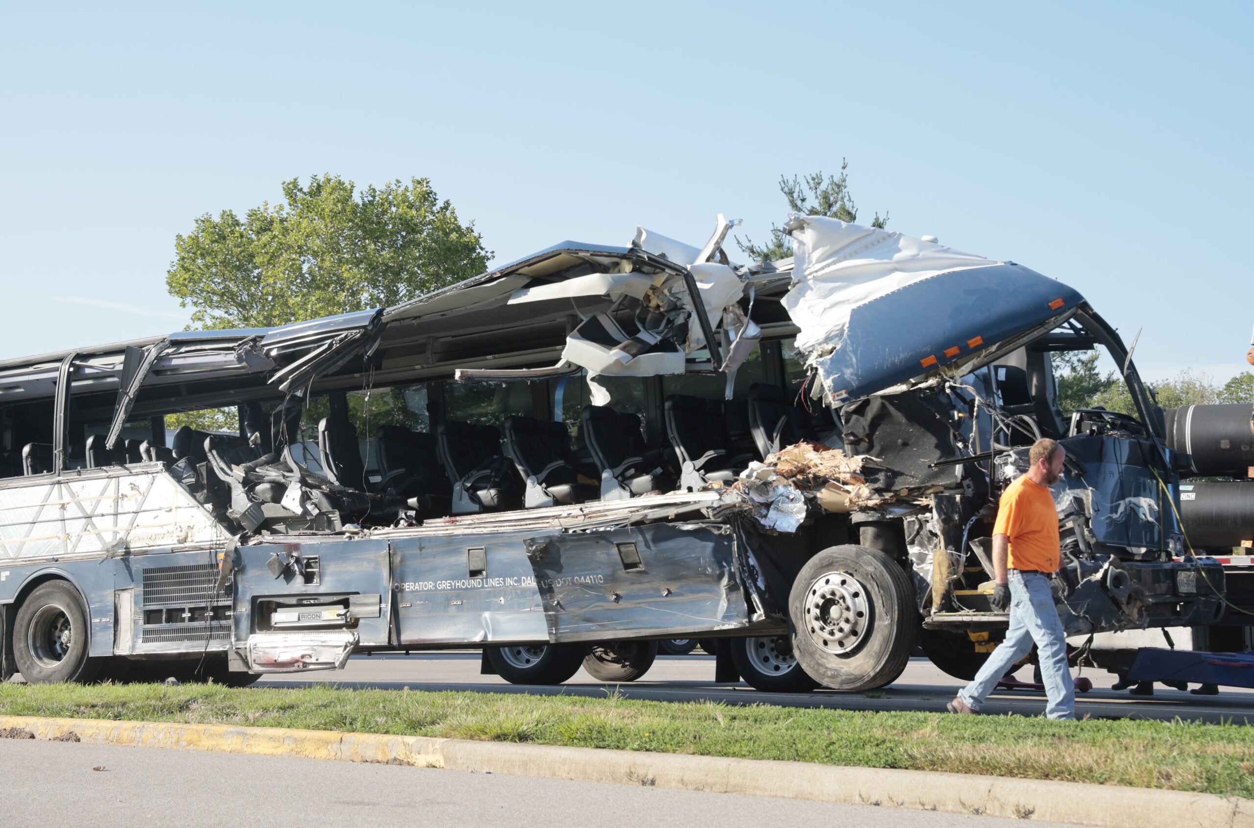 A worker helps clear the wreckage of a Greyhound bus that collided with tractor-trailers on the exi...