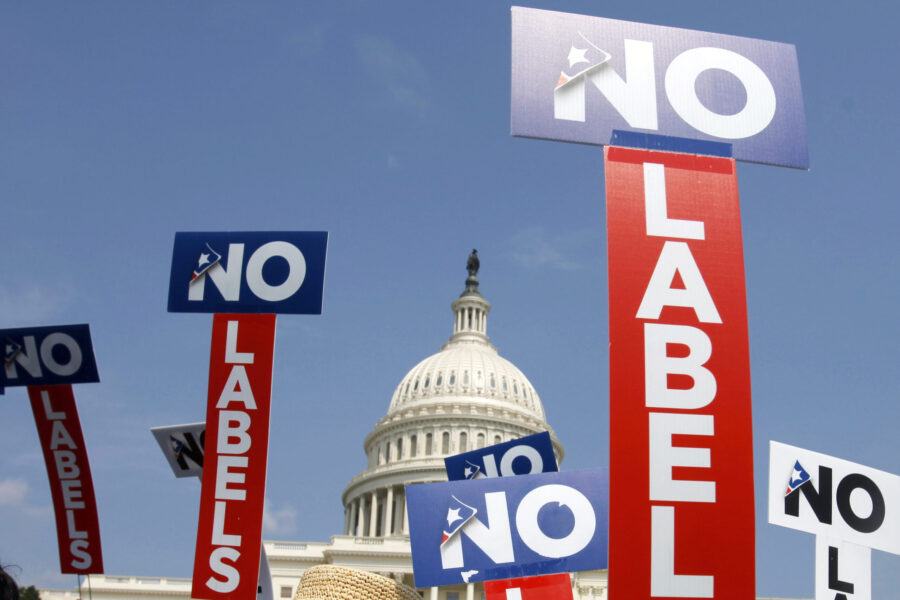 FILE - People with the group No Labels hold signs during a rally on Capitol Hill in Washington, Jul...
