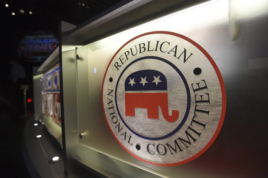 FILE - The Republican National Committee logo is shown on the stage as crew members work at the Nor...