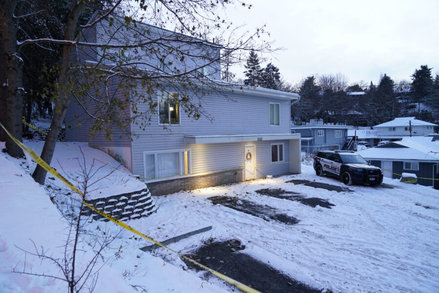 FILE - Bare spots are seen, Nov. 29, 2022, in the snowy parking lot in front of the home where four...