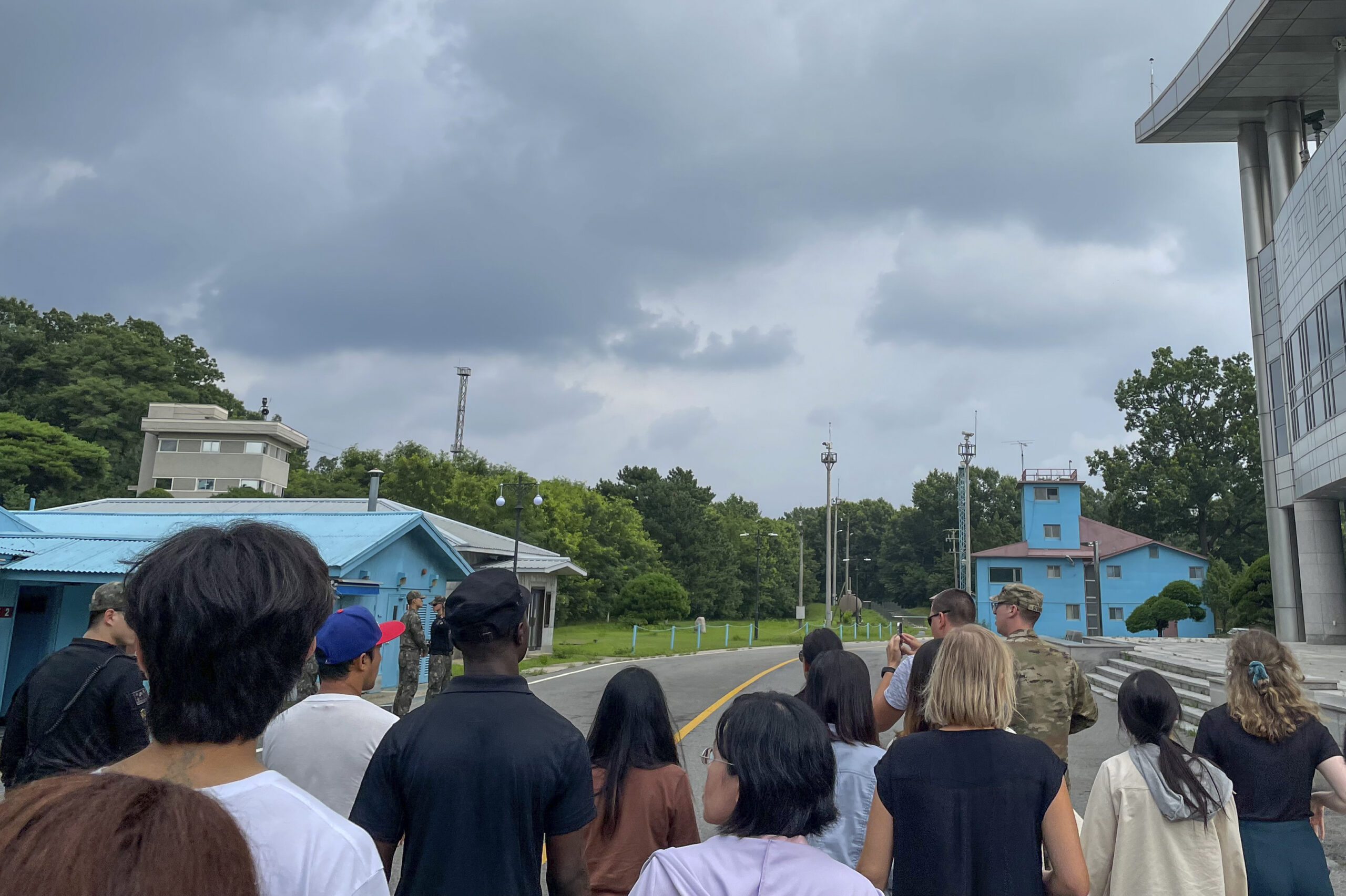 A group of tourists stand near a border station at Panmunjom in the Demilitarized Zone in Paju, Sou...