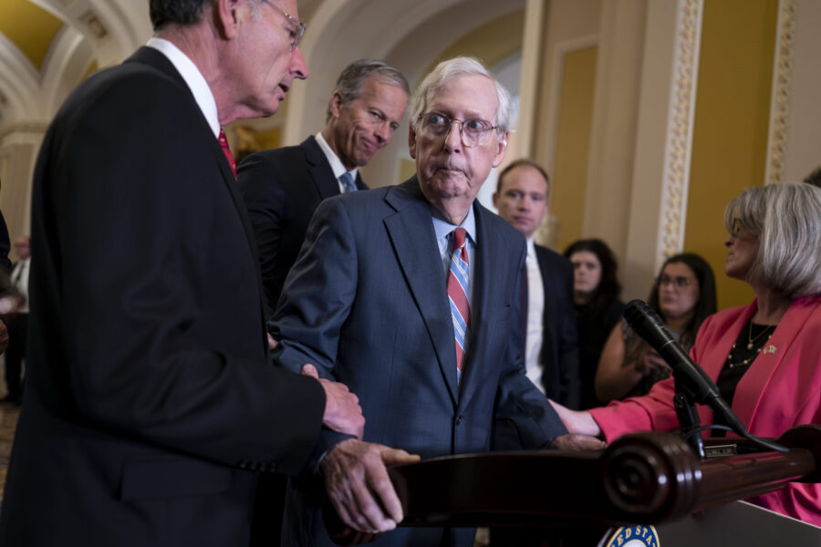 U.S. Senate Minority Leader Mitch McConnell, R-Ky., center, is helped by, from left, Sen. John Barr...