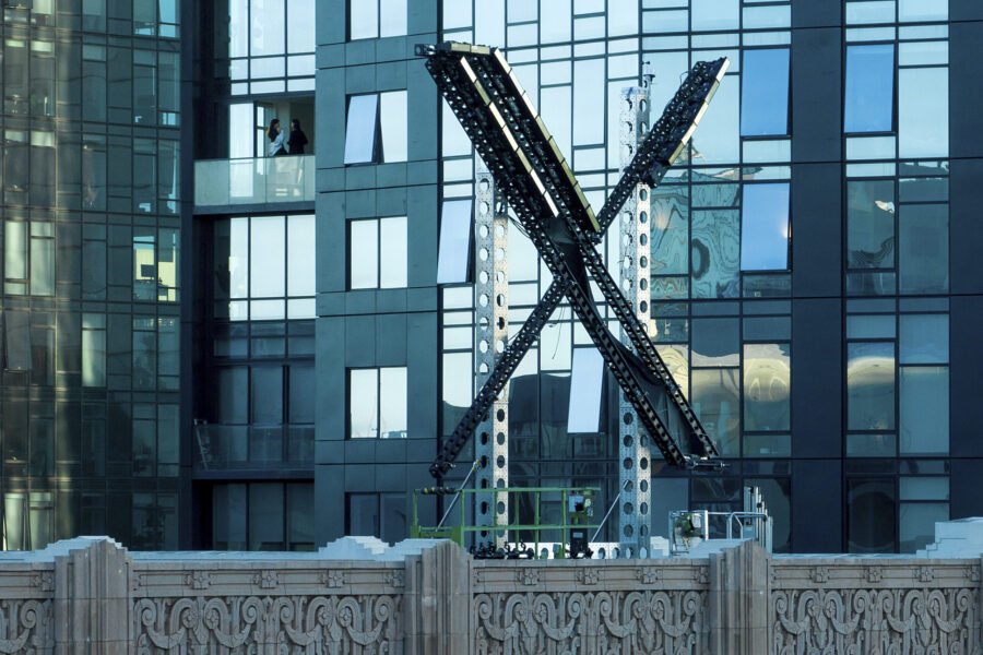A partially completed "X" sign rests atop the company headquarters, formerly known as Twitter, in d...
