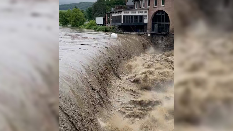 This screenshot from Vermont State Police shows floodwaters pouring over a dam on the Ottauquechee ...