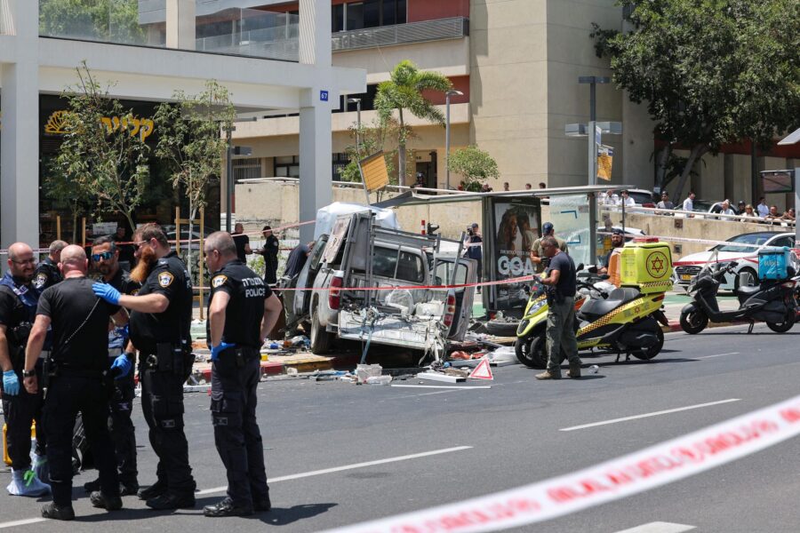 Members of Israeli security and emergency personnel work at the site of the car ramming attack in T...