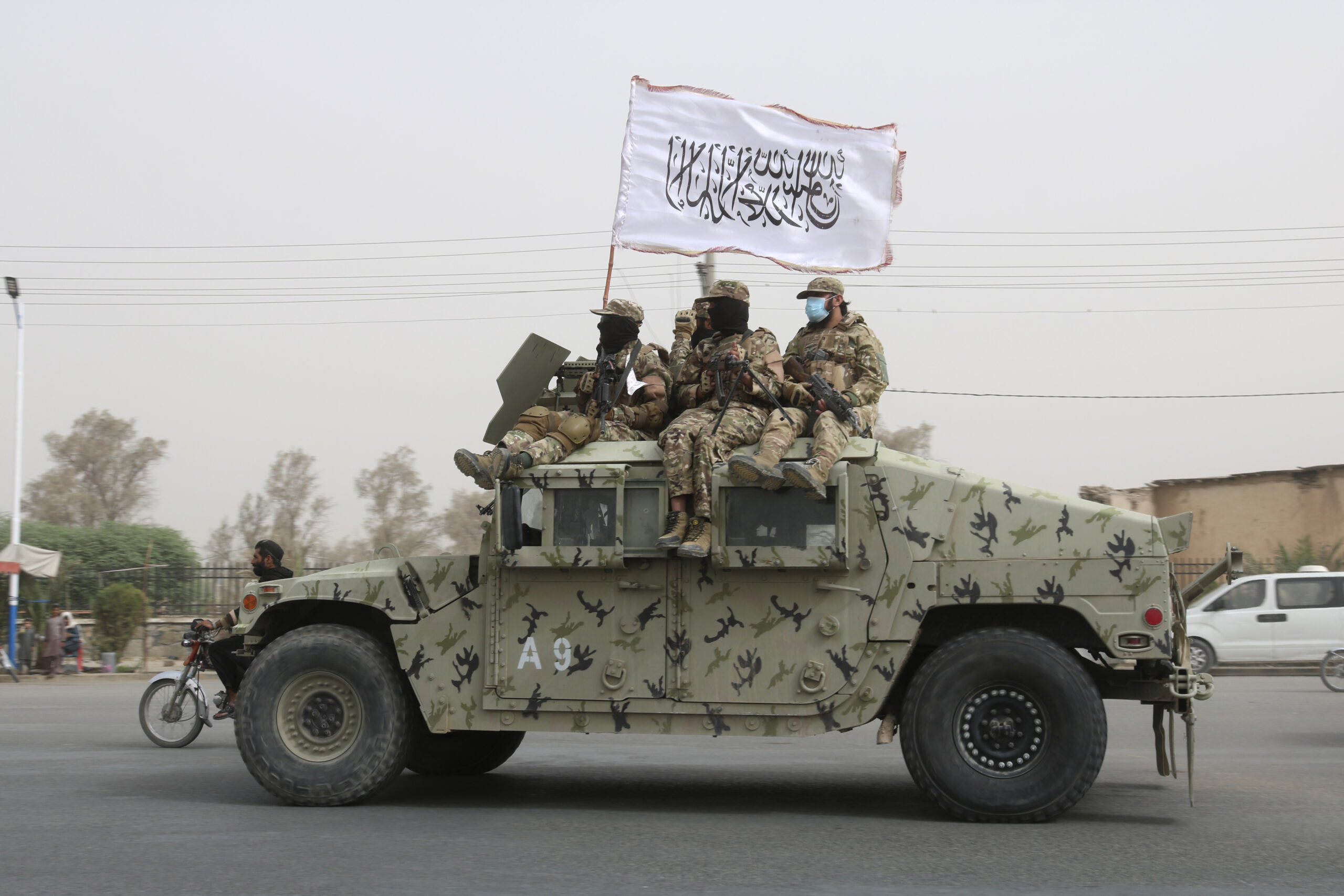 FILE - Taliban fighters patrol on the road during a celebration marking the second anniversary of t...