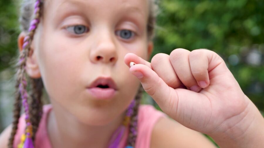 A girl examines her lost tooth....