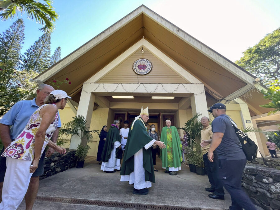 Most Rev. Clarence "Larry" Silva, the Bishop of Honolulu, greets parishioners after Mass at Sacred ...