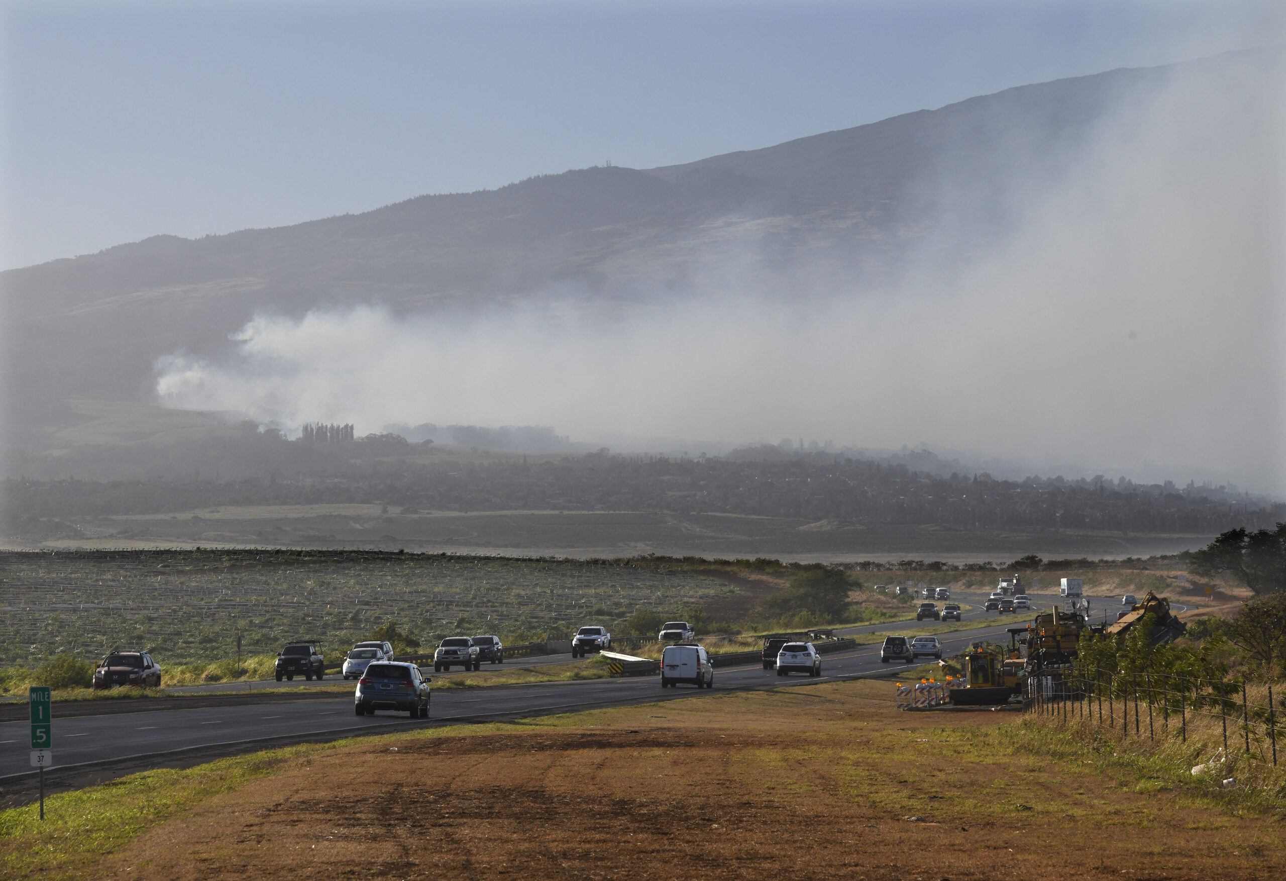 Smoke blows across the slope of Haleakala volcano on Maui, Hawaii, as a fire burns in Maui's upcoun...