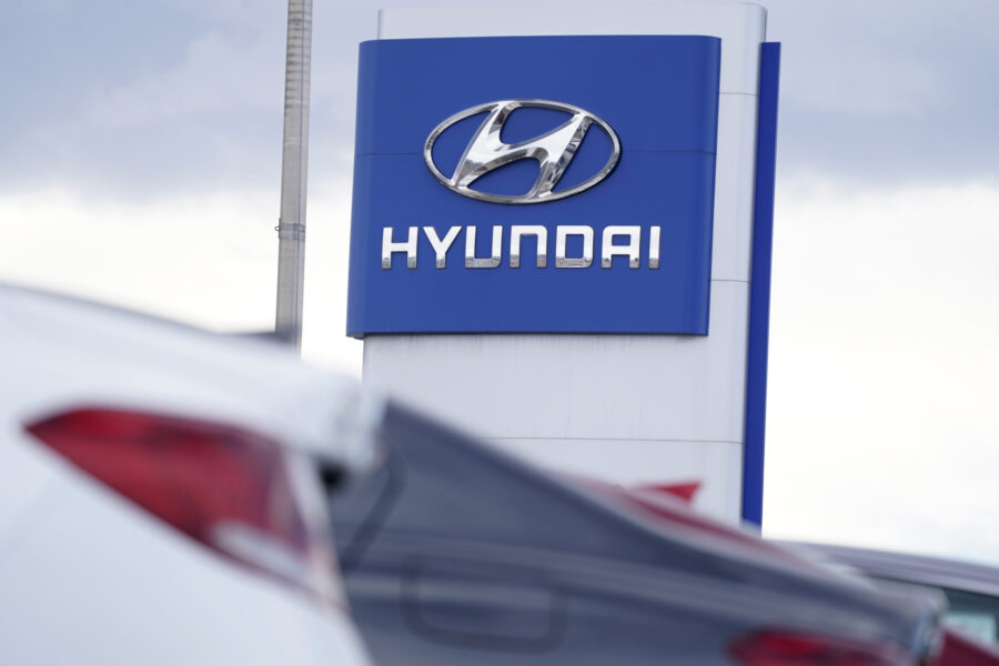FILE - The Hyundai company logo hangs over a long row of cars at a car dealership in Centennial, Co...