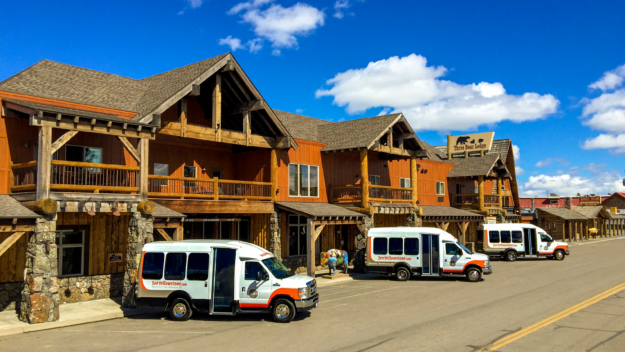 Yellowstone cabin with white tour vans parked in front
