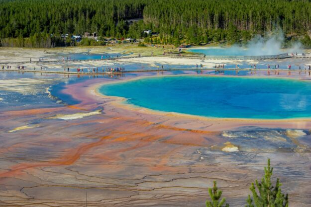 yellowstone geyzer with clear blue water contrasted with red dirt